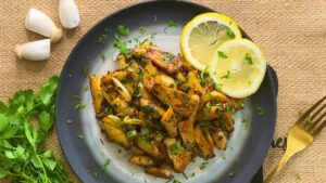 A Plate of Golden, Pan-Seared King Oyster Mushrooms Garnished with Fresh Parsley and Lemon Slices